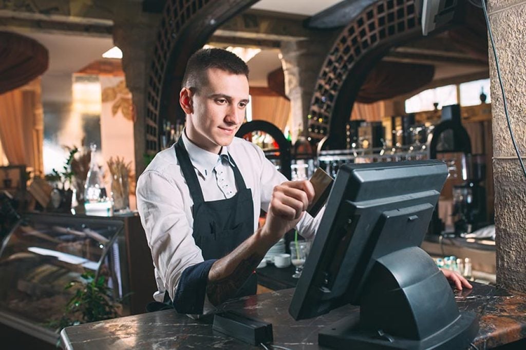 Server using POS system in restaurant