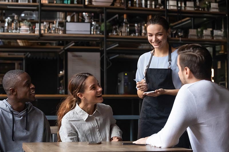 Waitress taking an order with a notepad at a table in a restaurant