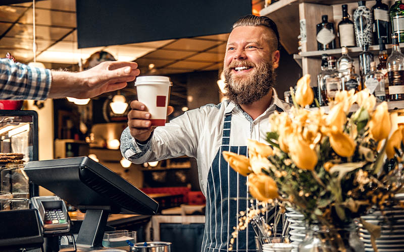 Coffee Shop Owner Serving Coffee to Customer