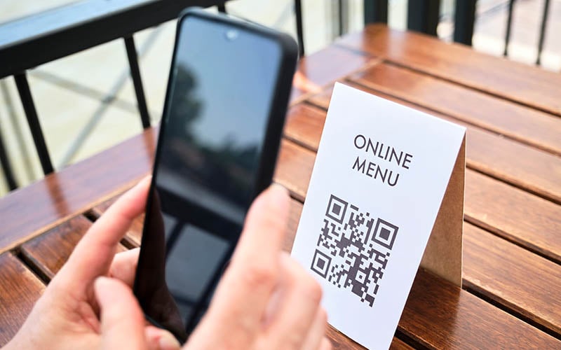 Customer using qr code on table to place an order from the menu and to make payment