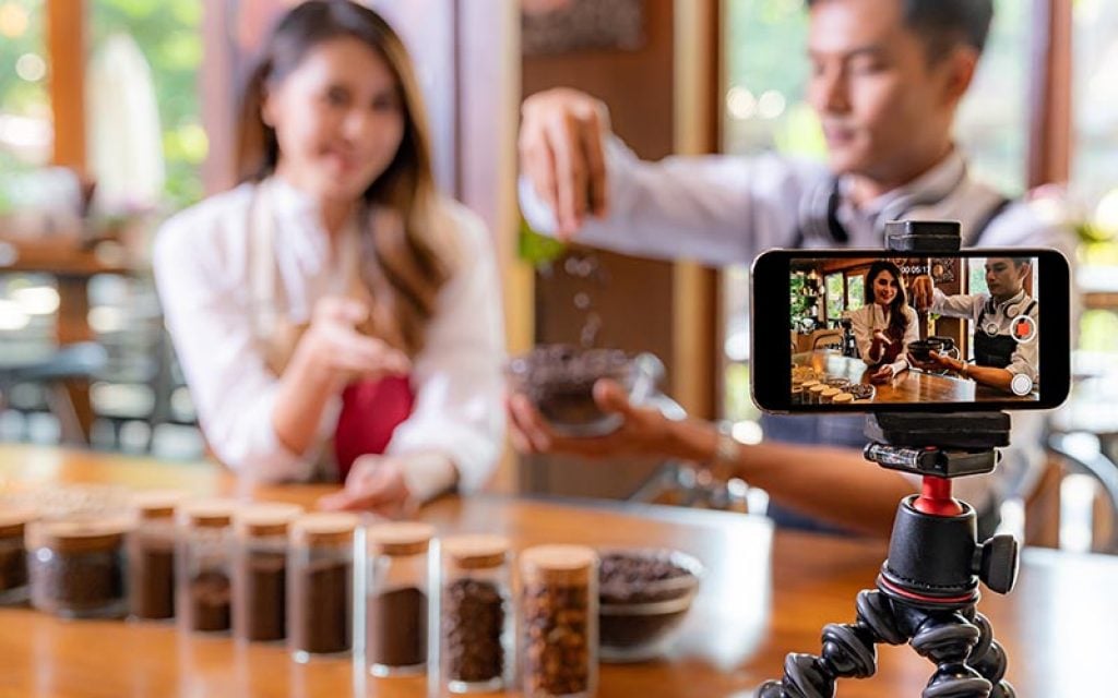 Chef creating TikTok video content in restaurant showing food preparation process